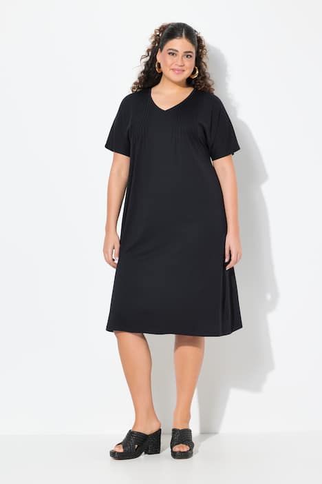 Robe en jersey à plis fantaisie. Col V et manches courtes. Coupe évasée