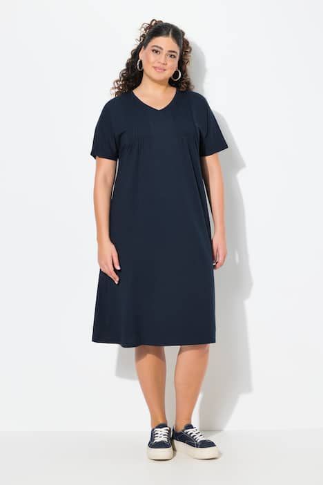 Robe en jersey à plis fantaisie. Col V et manches courtes. Coupe évasée