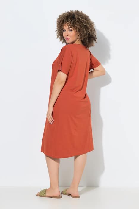 Robe en jersey à plis fantaisie. Col V et manches courtes. Coupe évasée