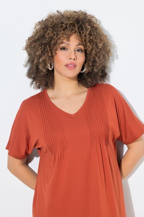 Robe en jersey à plis fantaisie. Col V et manches courtes. Coupe évasée