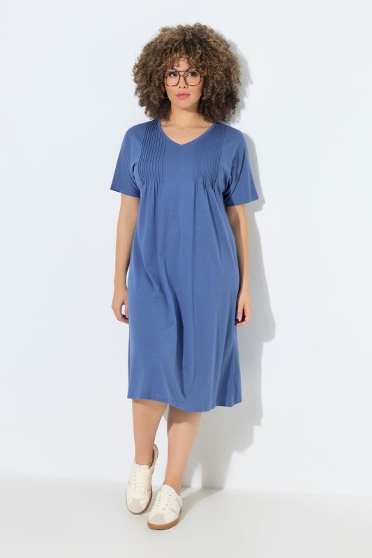 Robe en jersey à plis fantaisie. Col V et manches courtes. Coupe évasée