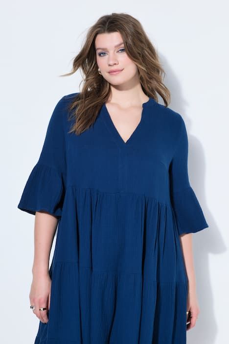 Robe maxi en mousseline, à col montant, manches 3/4 et volants. Coupe trapèze