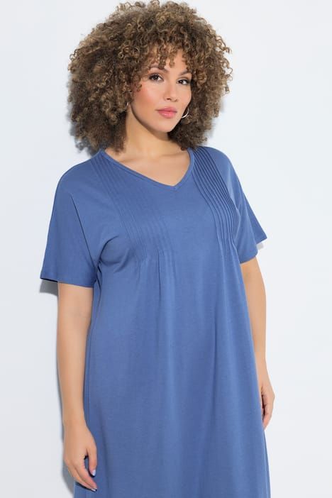 Robe en jersey à plis fantaisie. Col V et manches courtes. Coupe évasée