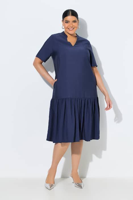 Robe midi, coupe évasée. Manches courtes et col en V. Volant à la base