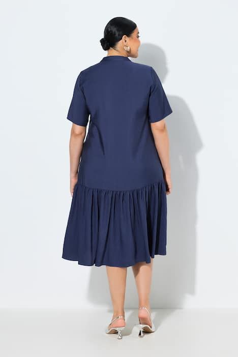 Robe midi, coupe évasée. Manches courtes et col en V. Volant à la base