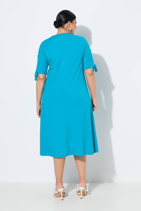 Robe longueur midi, décolleté rond et manches courtes fendues, coupe évasée