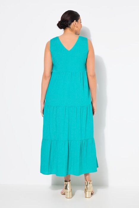 Robe maxi sans manches. Plusieurs niveaux de volants. Décolleté V. Coupe évasée